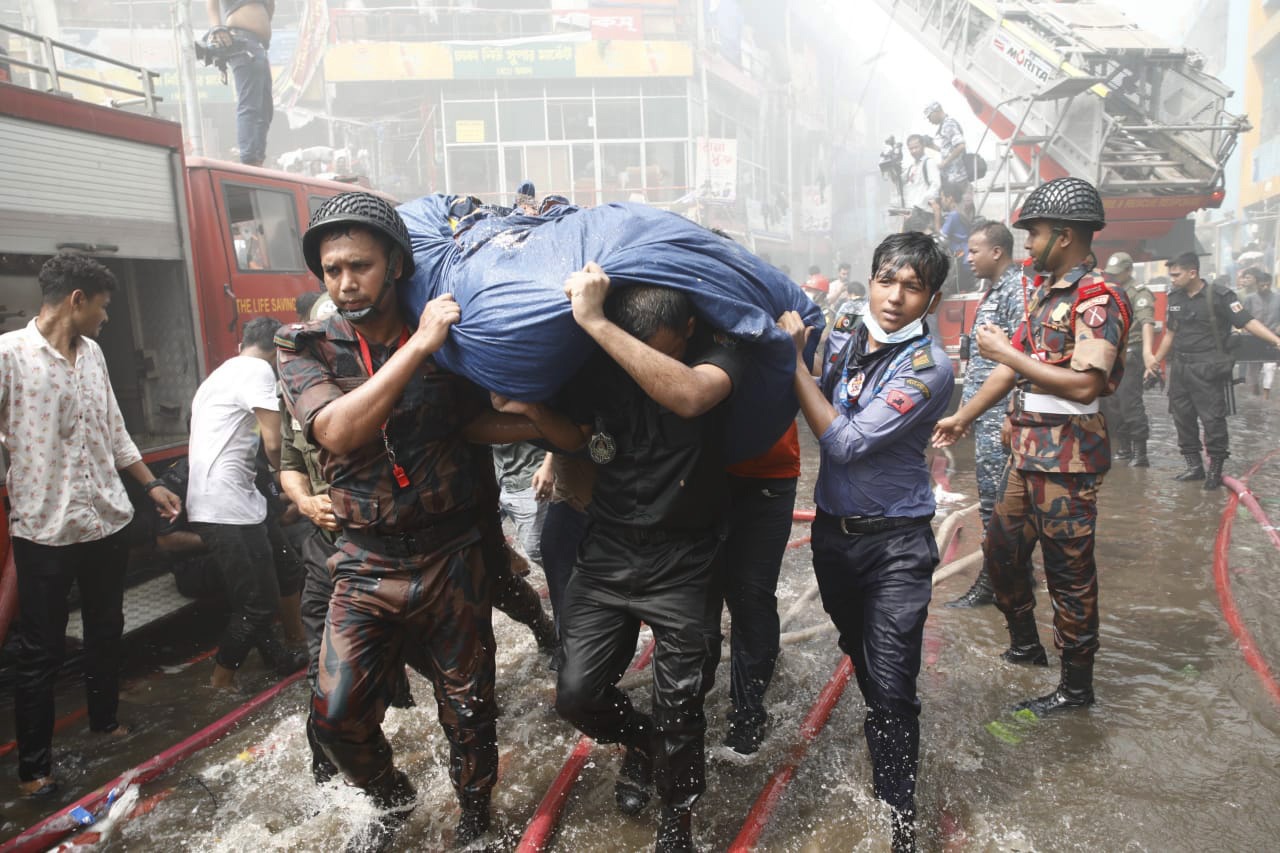 নিউ সুপার মার্কেটে আগুন: কাঁধে নিয়ে ব্যবসায়ীদের মালামাল সারাচ্ছেন পুলিশ